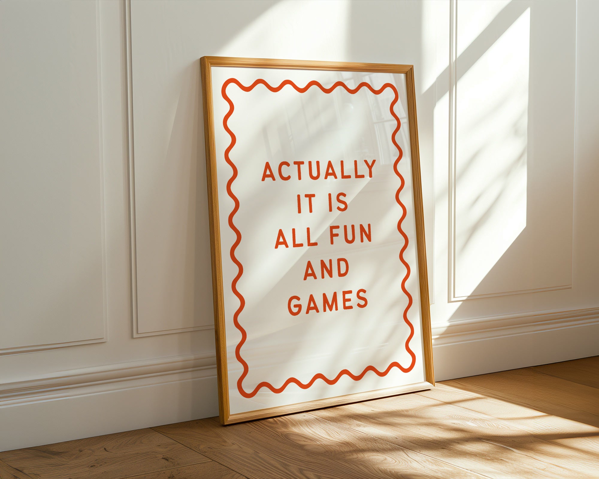 Framed poster with 'Actually it is all fun and games' text on a wall.
