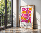 Framed Bauhaus poster with geometric design in a room with a window and wooden floor.