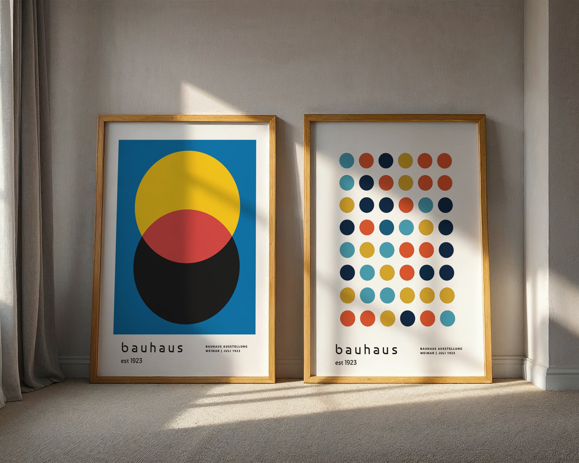 Two framed Bauhaus posters on a wall with sunlight casting shadows.