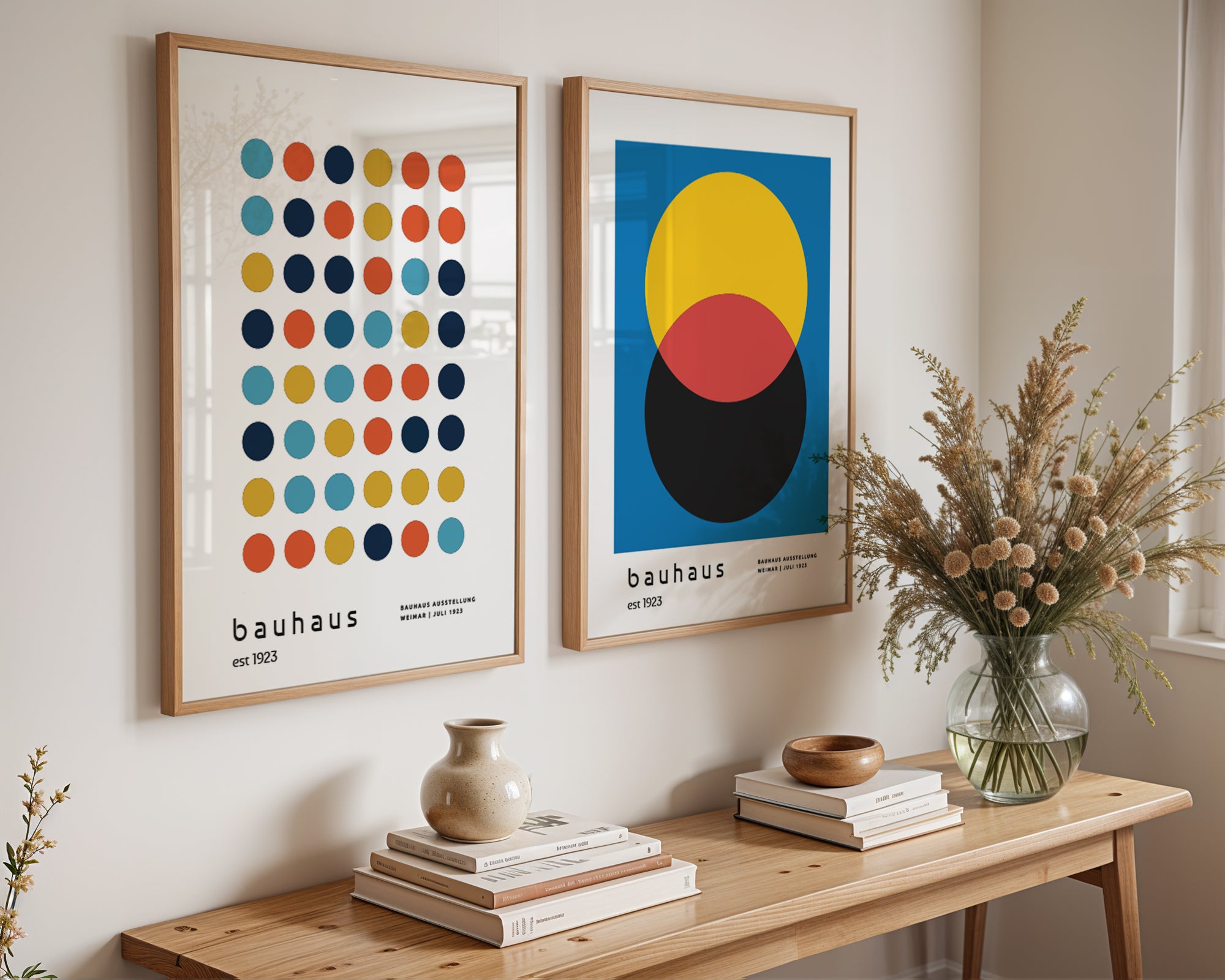 Two framed artworks on a wall above a wooden table with decorative items.