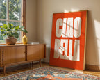 Room interior with a wooden sideboard, potted plant, and large 'CIAO BELLA' sign.