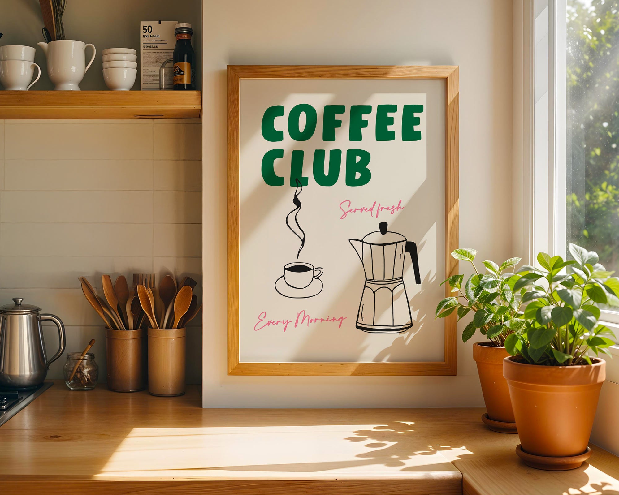 Framed 'Coffee Club' poster on a kitchen wall with coffee-making equipment and plants.