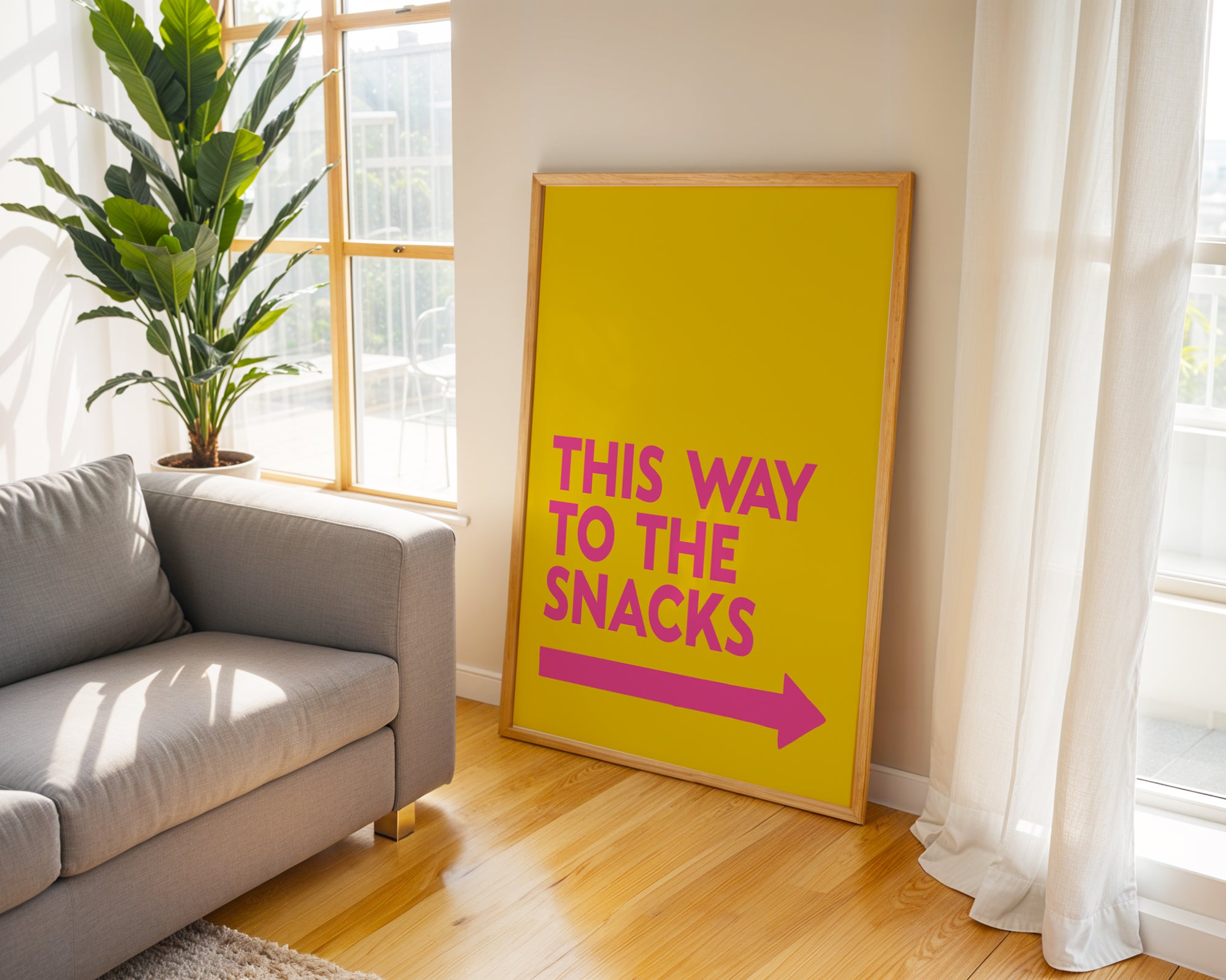 Yellow sign with pink text and arrow in a living room with a couch and plant.