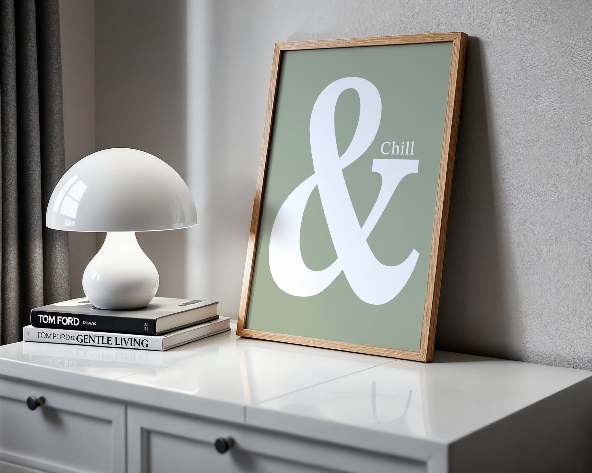 Framed artwork with an ampersand and 'Chill' text on a shelf with a lamp and books.