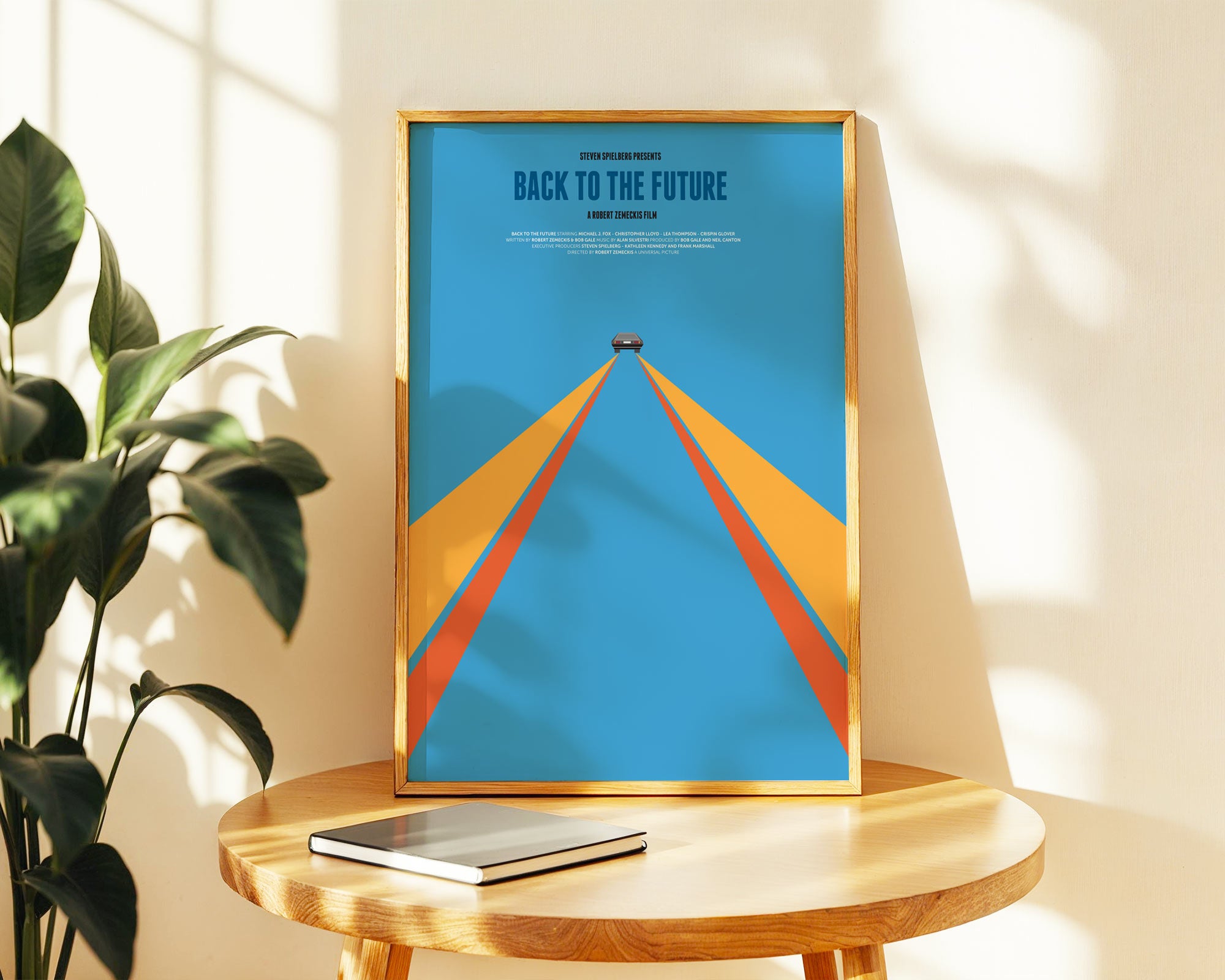 Framed 'Back to the Future' poster on a wooden table with a plant in the background