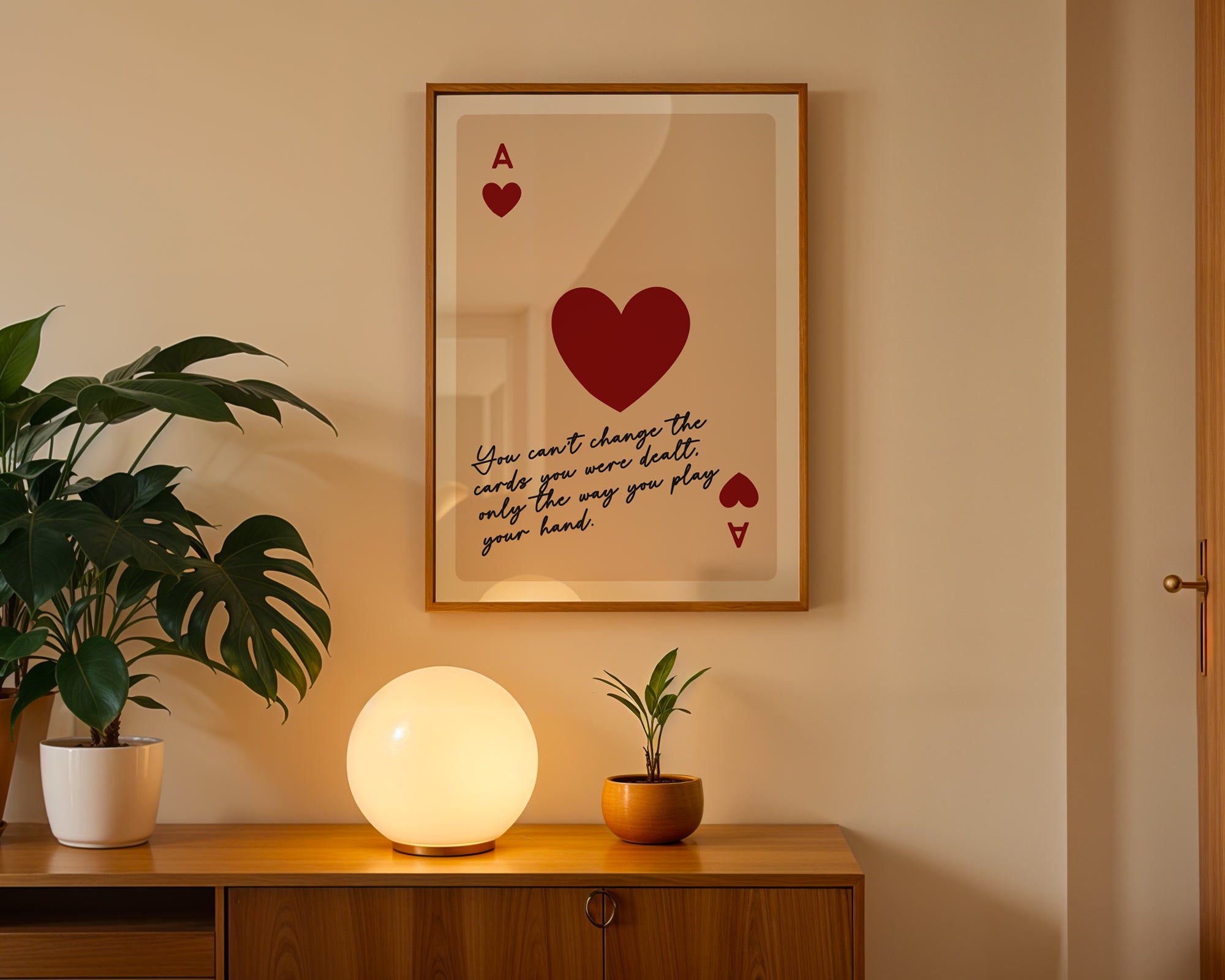 Framed artwork with a red heart and text on a wall above a wooden cabinet with decorative items.