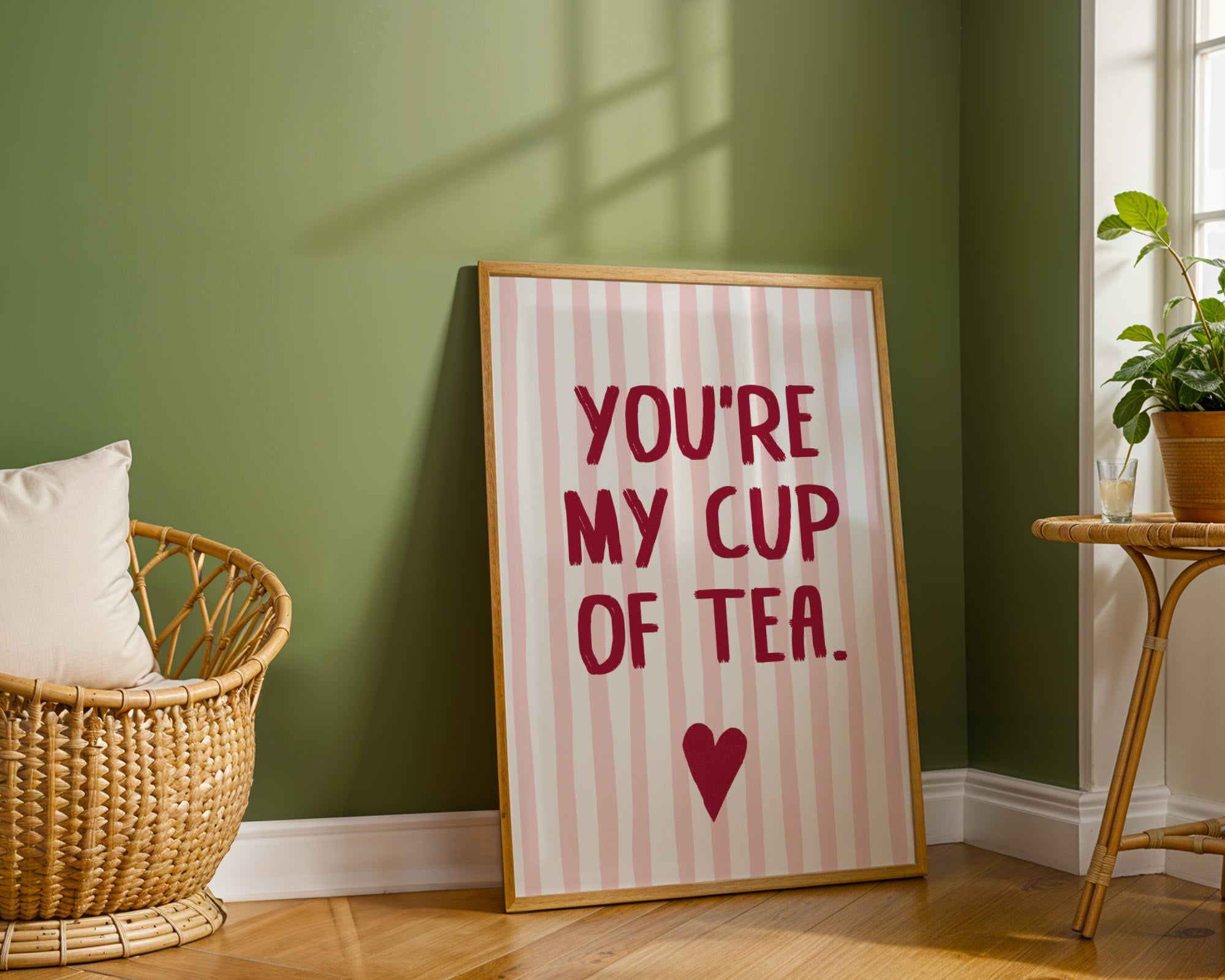 Framed print with 'You're my cup of tea' text in a room with a green wall and wooden floor.