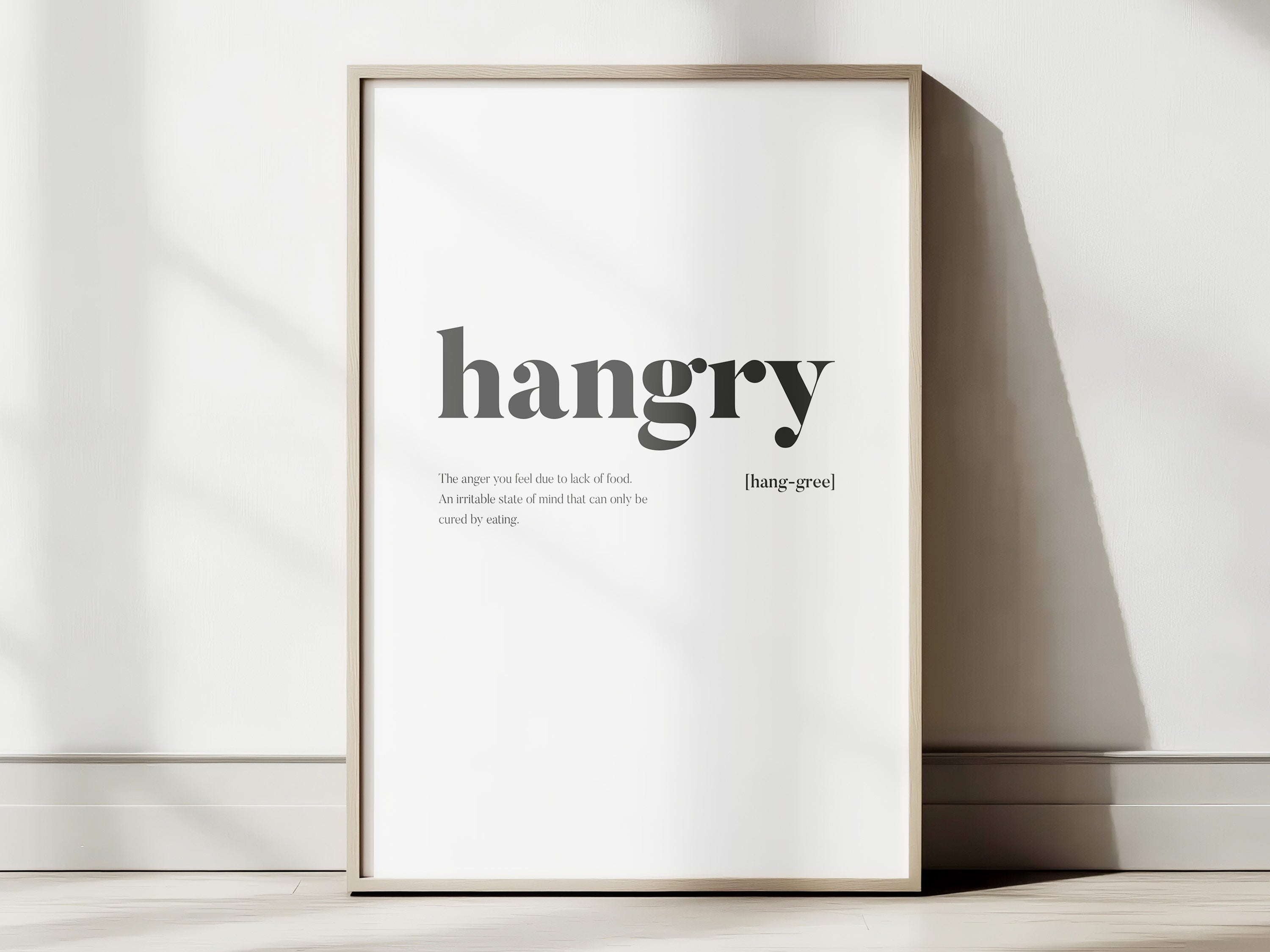 Framed print with the word 'hangry' and its definition on a white wall.