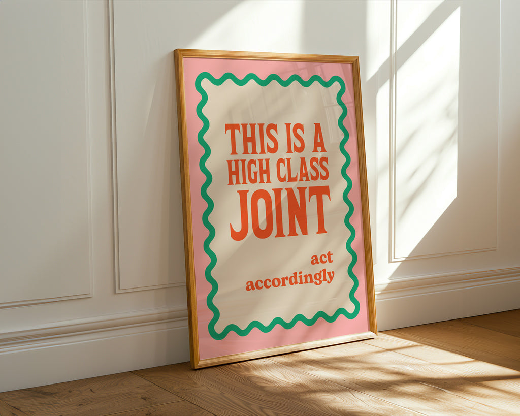 Framed poster with text 'This is a high class joint act accordingly' on a wall.