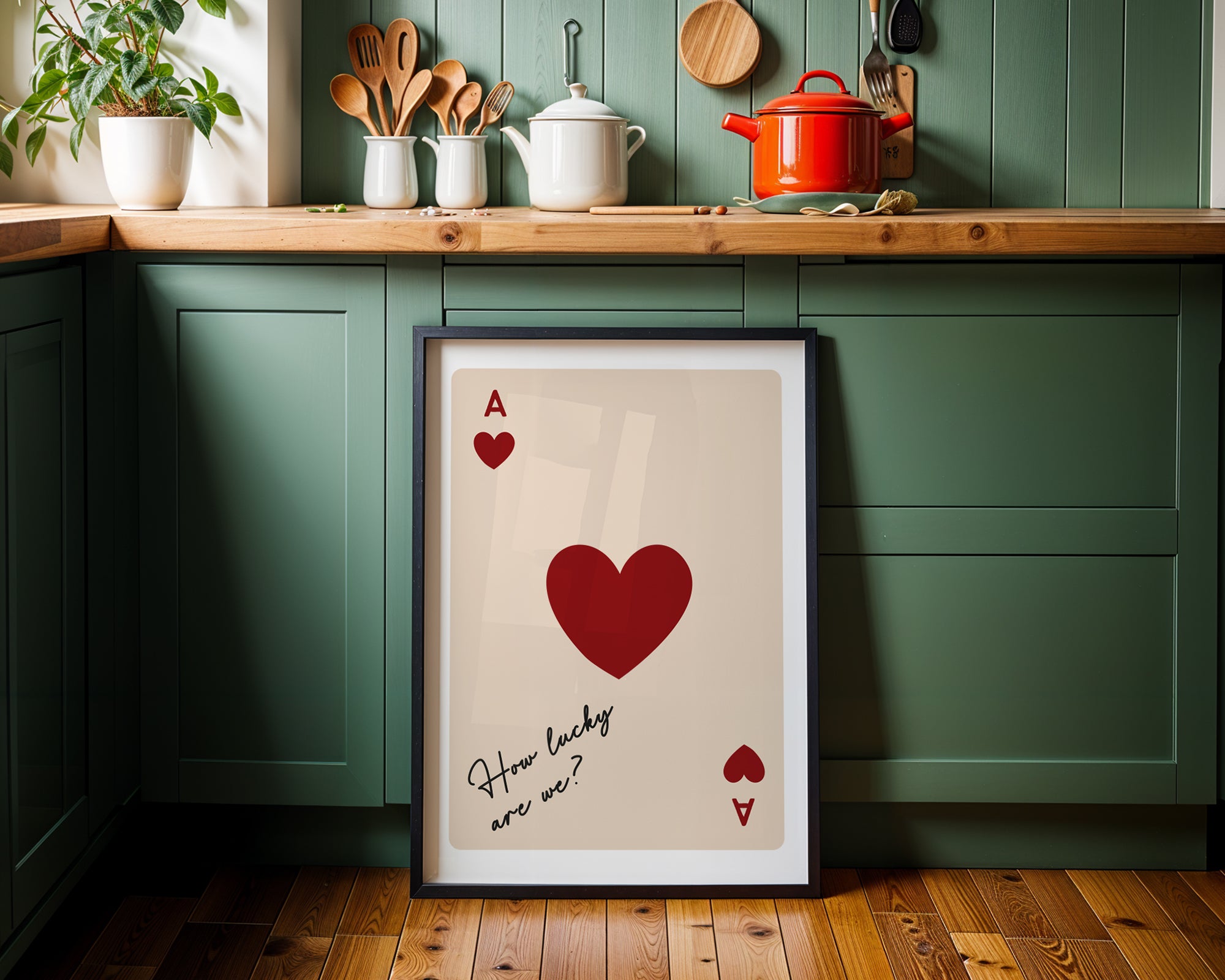 Framed playing card with red heart and text on a kitchen counter.