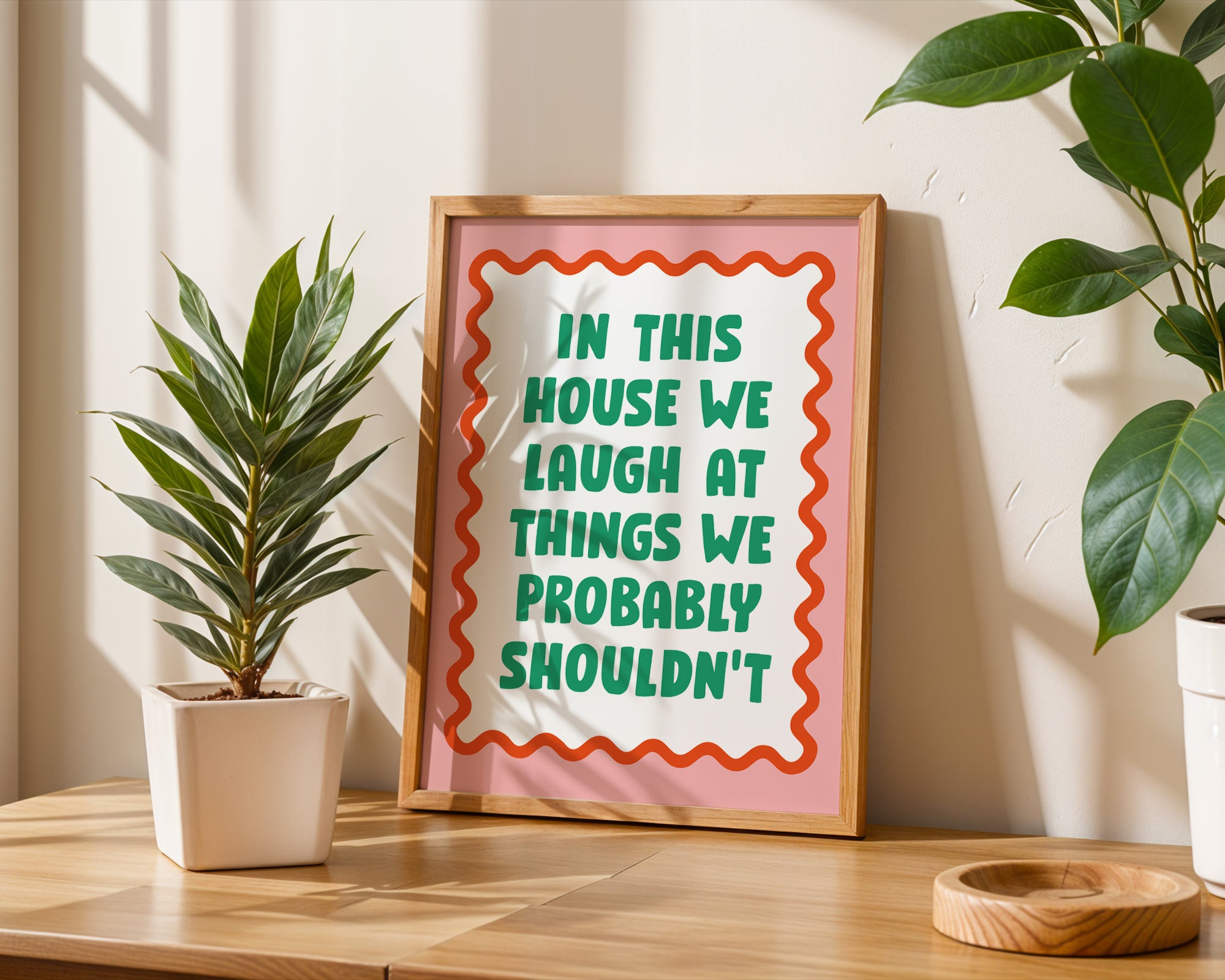 Framed sign with humorous quote on a table with plants