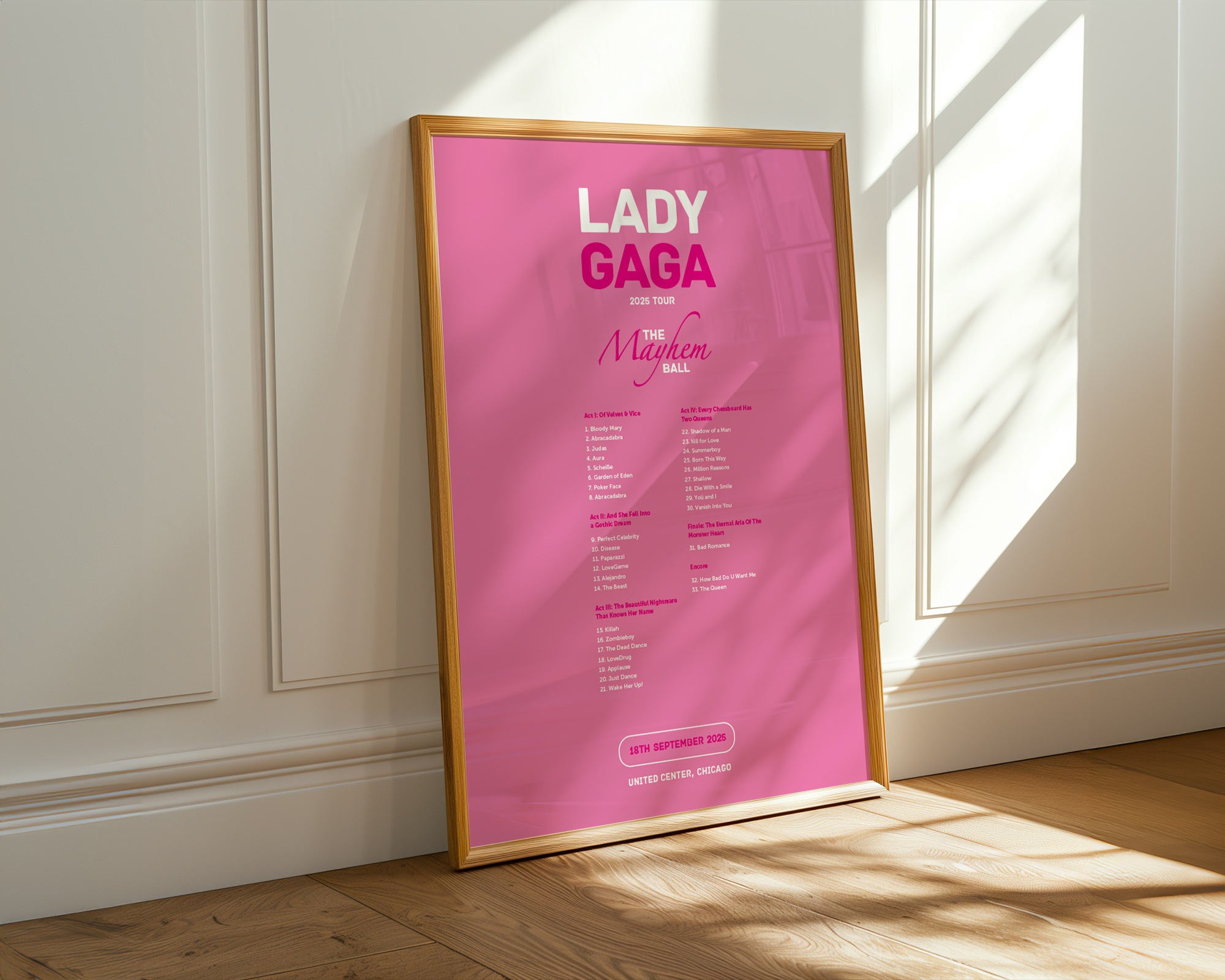 Framed poster of Lady Gaga on a wall with sunlight casting shadows.
