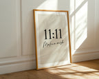 Framed artwork with '11:11 Make a wish' text on a wall.