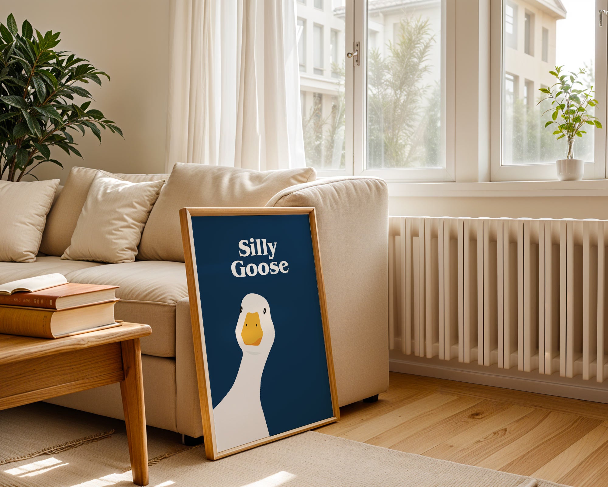 Framed artwork with a goose illustration and 'Silly Goose' text in a living room.