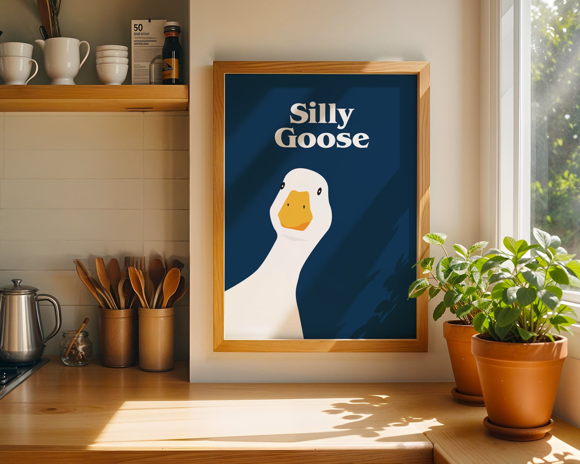 Framed artwork of a goose with 'Silly Goose' text in a kitchen setting