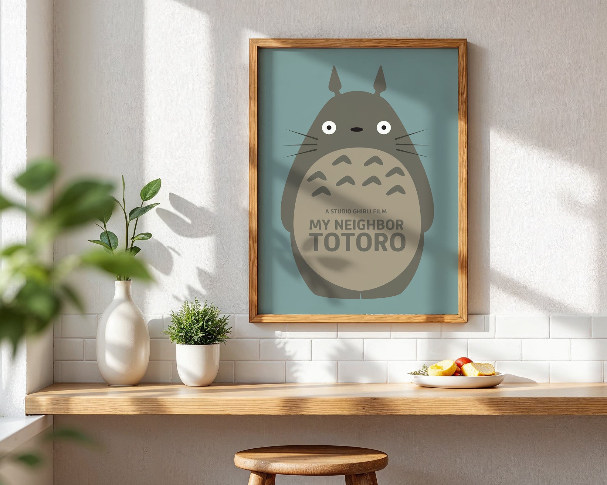 Framed 'My Neighbor Totoro' artwork on a wall with a wooden shelf below.