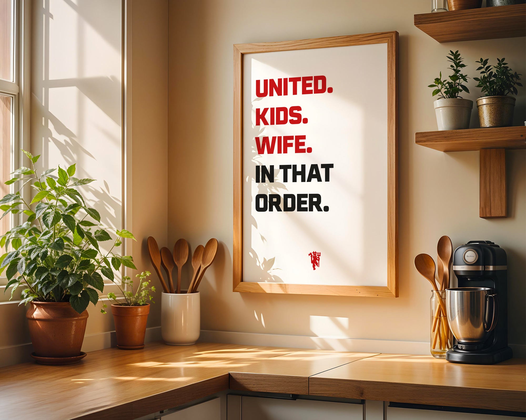 Kitchen interior with a framed quote on the wall, plants, and kitchen utensils.