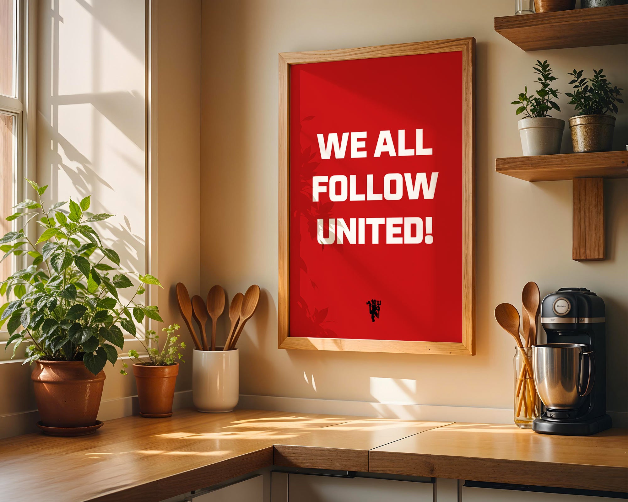 Kitchen interior with a red framed poster reading 'WE ALL FOLLOW UNITED!' on a wall.